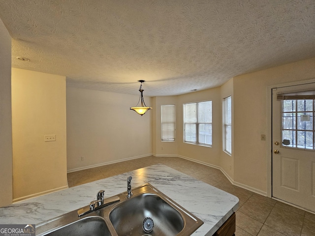 kitchen featuring pendant lighting, a textured ceiling, tile patterned floors, and sink