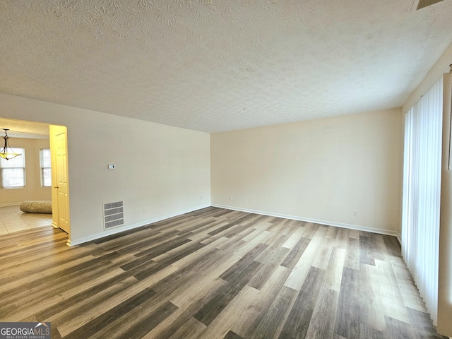 empty room featuring hardwood / wood-style floors and a textured ceiling