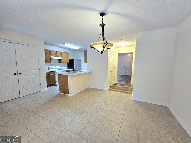 kitchen with pendant lighting, white appliances, kitchen peninsula, and light tile patterned floors