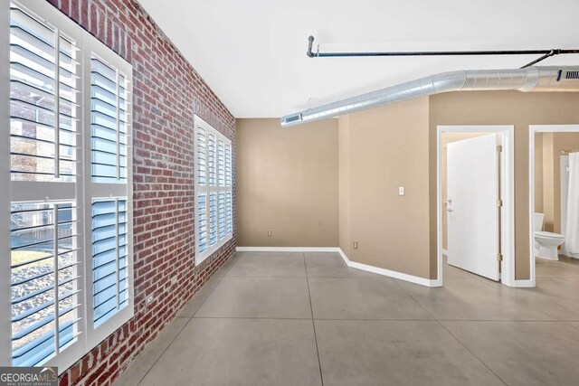 unfurnished dining area featuring brick wall