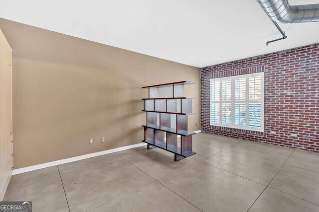 laundry room with light tile patterned floors and stacked washer / drying machine