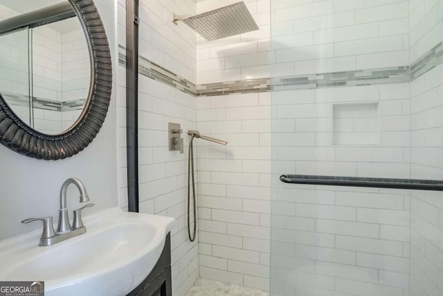 bathroom featuring tiled shower and sink