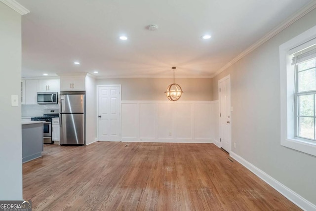 interior space featuring light wood-type flooring, crown molding, and an inviting chandelier