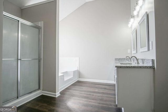 bathroom with hardwood / wood-style floors, vanity, lofted ceiling, and shower with separate bathtub