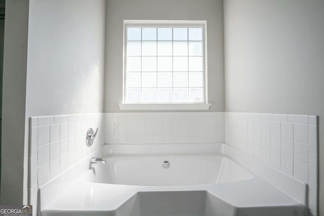 bathroom with a washtub and a healthy amount of sunlight