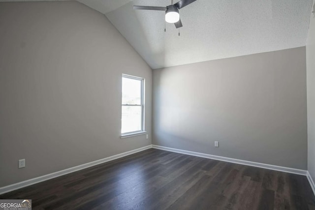 spare room featuring a textured ceiling, dark hardwood / wood-style floors, vaulted ceiling, and ceiling fan