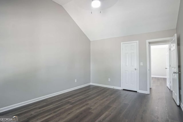 interior space with ceiling fan, dark hardwood / wood-style flooring, and vaulted ceiling