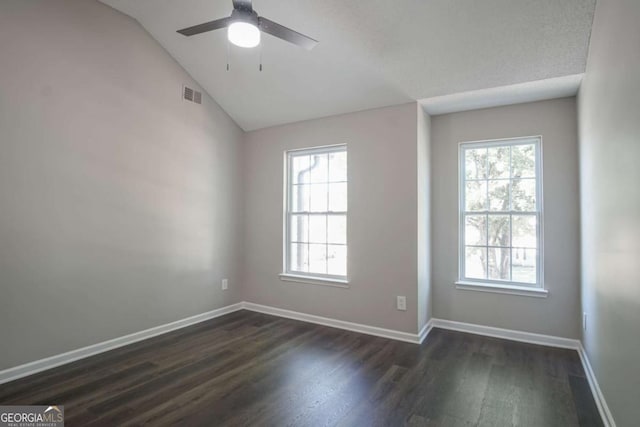 spare room featuring dark hardwood / wood-style floors, ceiling fan, lofted ceiling, and a wealth of natural light