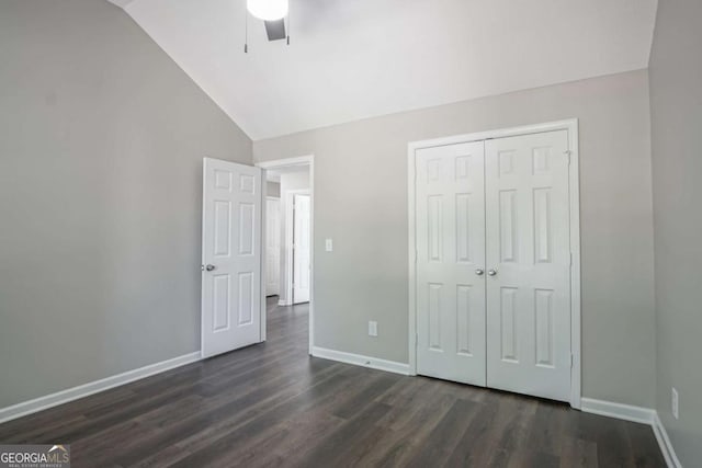 unfurnished bedroom featuring ceiling fan, a closet, dark hardwood / wood-style floors, and lofted ceiling