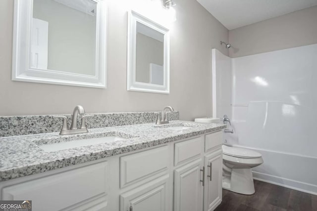 full bathroom featuring wood-type flooring, vanity, toilet, and tub / shower combination