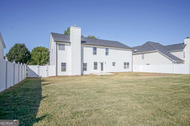 rear view of house featuring a lawn