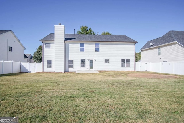 back of house with a patio and a lawn