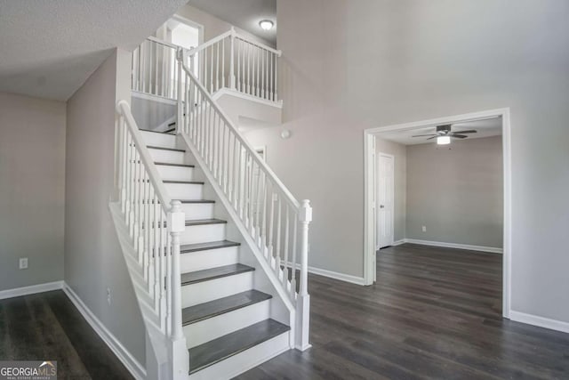 stairway featuring wood-type flooring, a textured ceiling, and ceiling fan