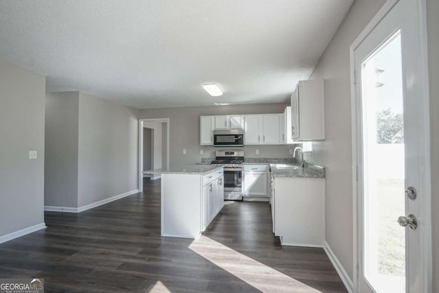 kitchen with sink, a center island, white cabinets, and appliances with stainless steel finishes