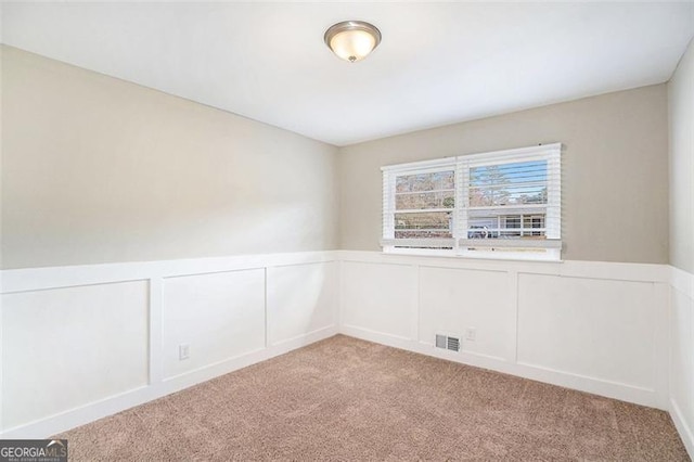 unfurnished room featuring light colored carpet