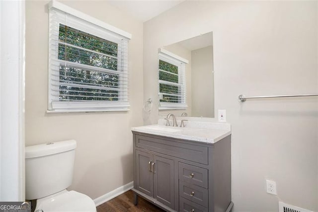 bathroom with hardwood / wood-style floors, vanity, and toilet