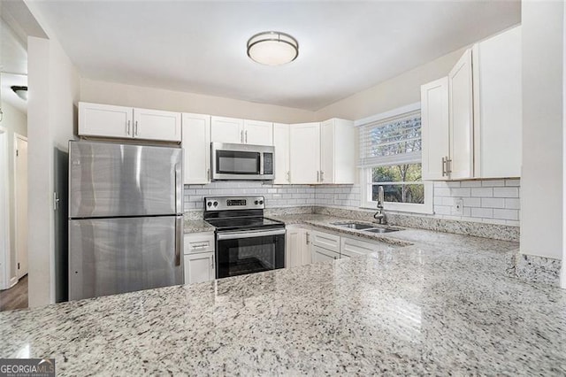 kitchen featuring white cabinetry, light stone counters, sink, and stainless steel appliances