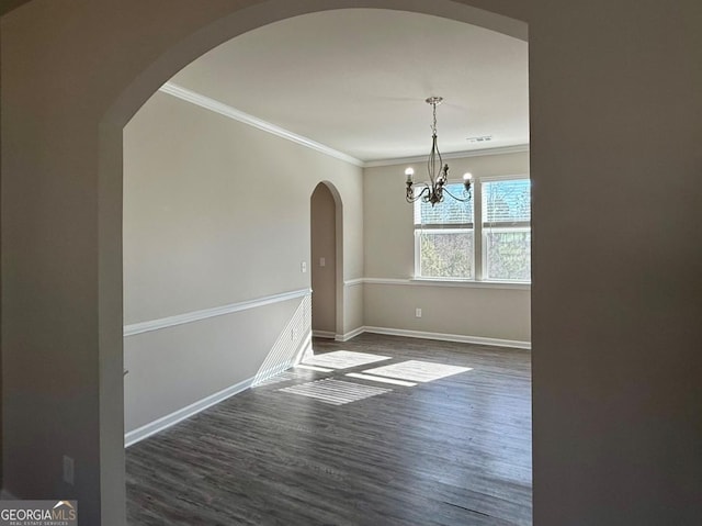 unfurnished dining area featuring crown molding, dark wood-type flooring, and an inviting chandelier