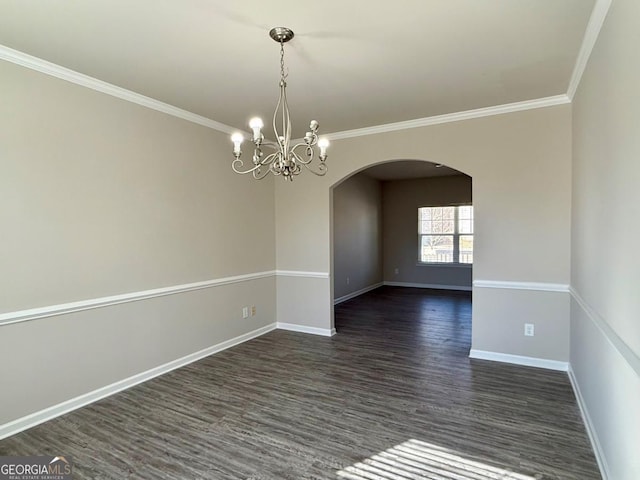 spare room featuring dark hardwood / wood-style flooring, an inviting chandelier, and ornamental molding