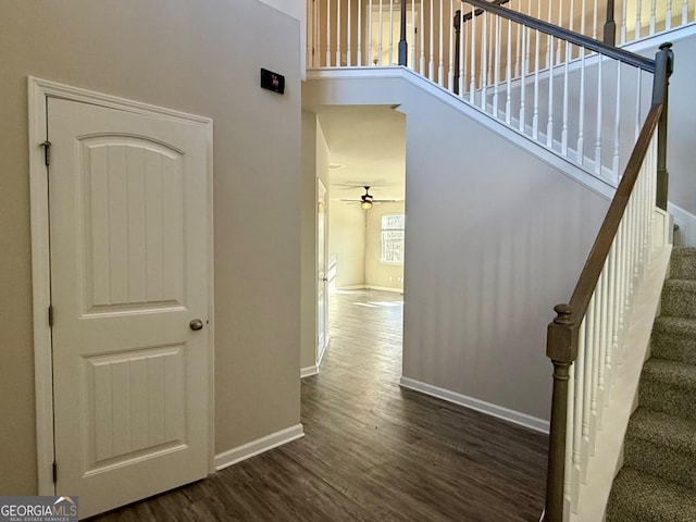 interior space featuring hardwood / wood-style floors, ceiling fan, and a high ceiling