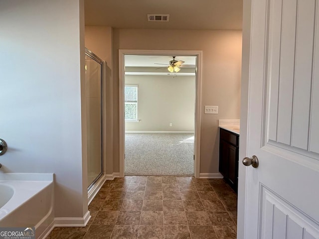 bathroom featuring ceiling fan, vanity, and independent shower and bath