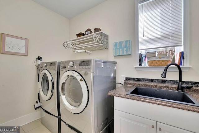 washroom with cabinets, tile patterned floors, sink, washing machine and clothes dryer, and plenty of natural light