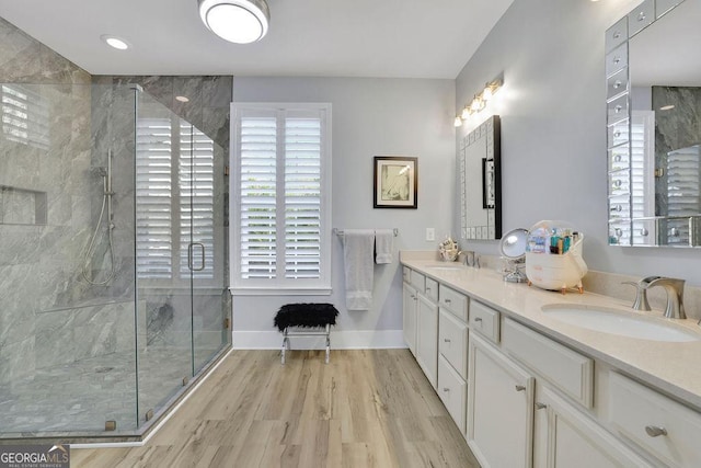 bathroom with wood-type flooring, vanity, and walk in shower