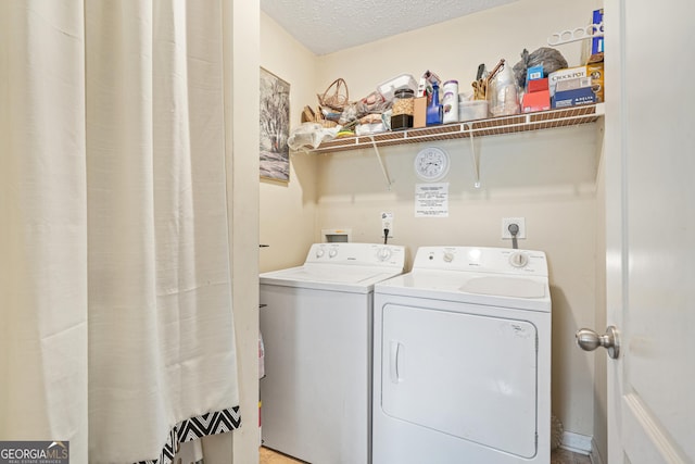 clothes washing area with washer and dryer and a textured ceiling