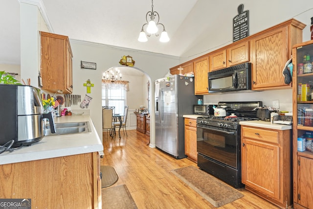 kitchen with a notable chandelier, decorative light fixtures, light hardwood / wood-style flooring, and black appliances