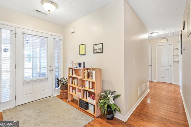 foyer with hardwood / wood-style floors and a textured ceiling