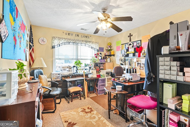 office space featuring ceiling fan, light colored carpet, and a textured ceiling