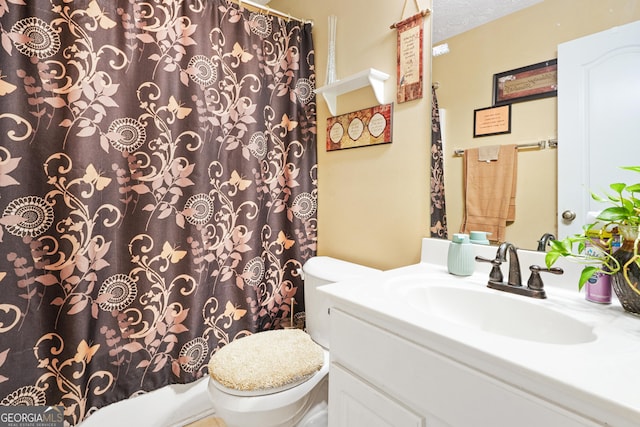 bathroom featuring vanity, a textured ceiling, and toilet