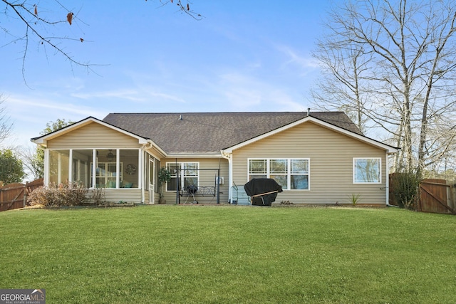 back of property with a sunroom and a lawn