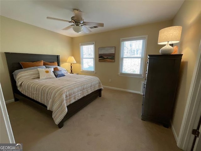 carpeted bedroom featuring multiple windows and ceiling fan