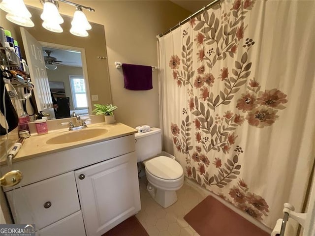 bathroom featuring vanity, ceiling fan with notable chandelier, tile patterned flooring, toilet, and curtained shower