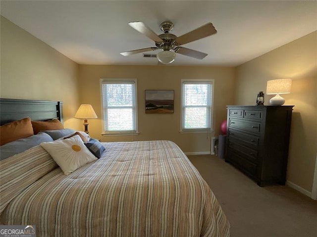 carpeted bedroom with multiple windows and ceiling fan