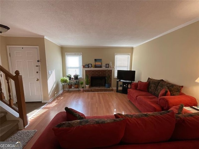 living room featuring crown molding, a fireplace, a textured ceiling, and hardwood / wood-style flooring