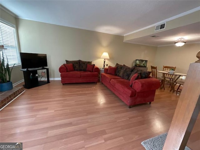 living room with crown molding and light hardwood / wood-style flooring