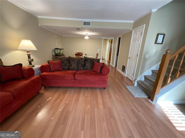 living room featuring ornamental molding and light hardwood / wood-style flooring