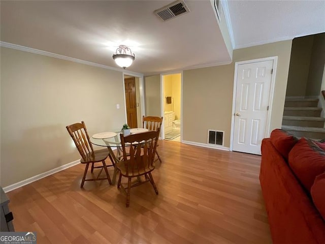 dining room featuring hardwood / wood-style flooring and crown molding