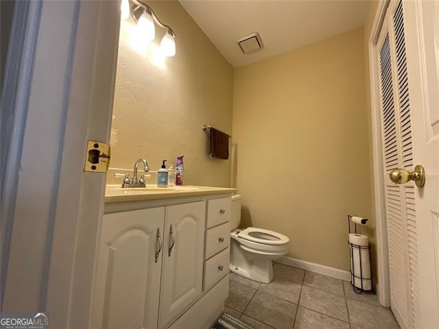 bathroom featuring tile patterned flooring, vanity, and toilet