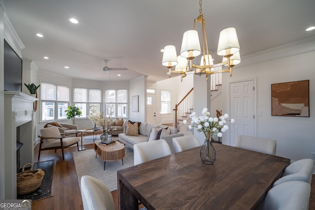 dining room featuring ornamental molding, a healthy amount of sunlight, ceiling fan with notable chandelier, and dark hardwood / wood-style flooring