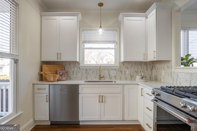 kitchen with appliances with stainless steel finishes, sink, white cabinets, and decorative backsplash