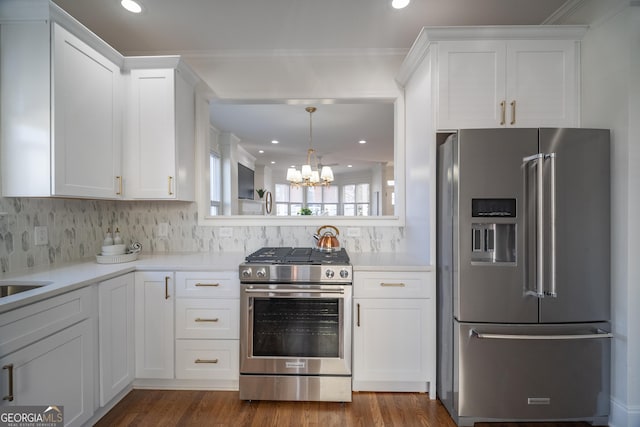 kitchen featuring dark hardwood / wood-style flooring, decorative backsplash, white cabinets, and appliances with stainless steel finishes