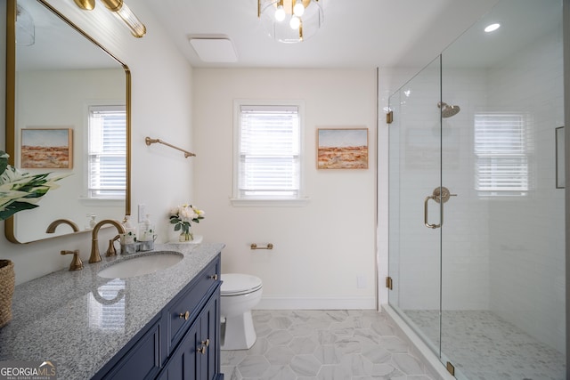 bathroom with vanity, toilet, and a shower with shower door