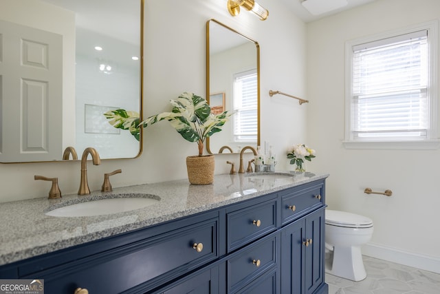 bathroom with vanity, toilet, and a healthy amount of sunlight