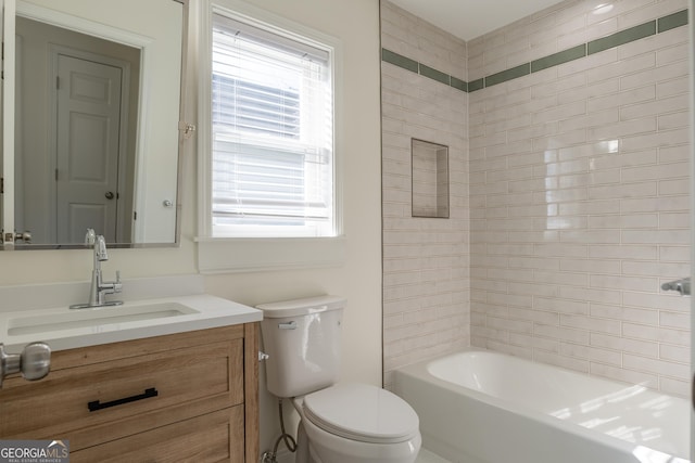 full bathroom with vanity, tiled shower / bath, and toilet