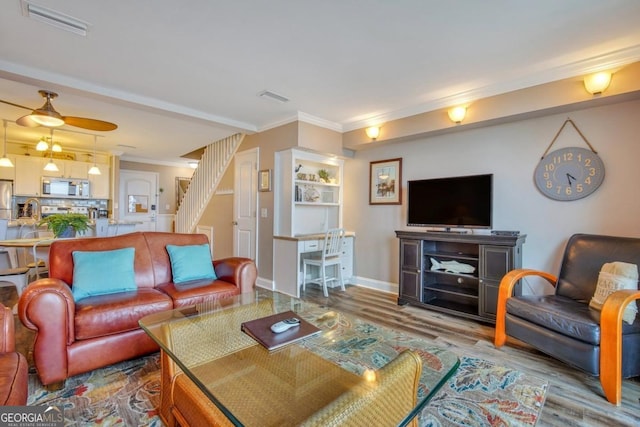 living room with crown molding and hardwood / wood-style flooring