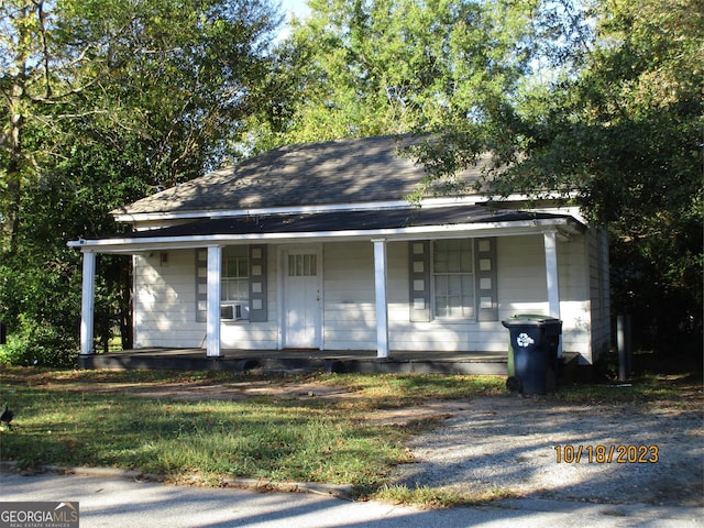 bungalow with covered porch and cooling unit