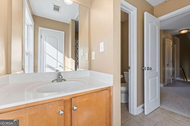 bathroom featuring tile patterned flooring, vanity, and toilet